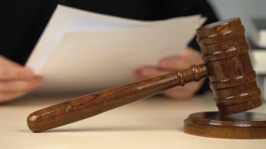 Yargıç kanıt listesine bakıyor, mahkeme duruşması sırasında belgeleri kontrol ediyor.