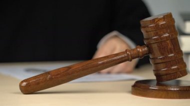 Yargıç gözlük takıyor, mahkeme salonunda masabaşında kağıtları imzalıyor, işgal