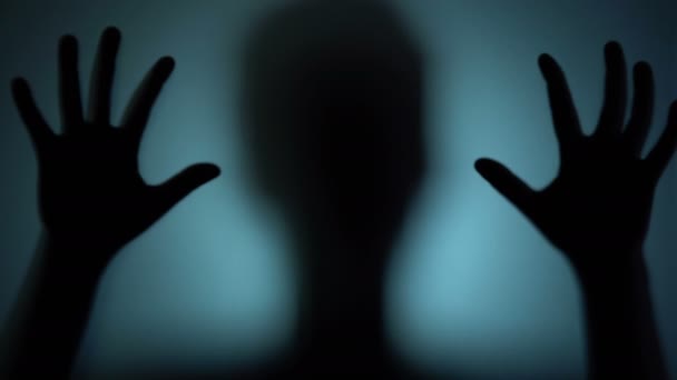 Ψυχωτικός άνθρωπος που χτυπάει σε γυαλί, τρομακτική σιλουέτα, φάντασμα από έναν άλλο κόσμο — Αρχείο Βίντεο