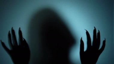 Cam arkasında uzun keskin çivi ile kadının silueti, sahip kişi