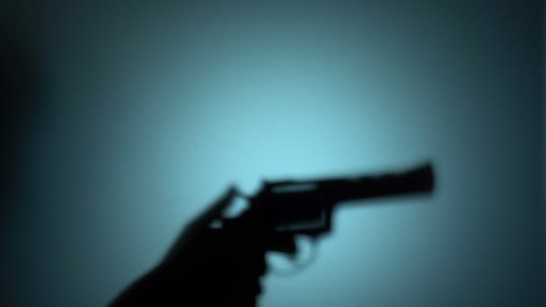 Silhouet van een killer Raising revolver, het aansteken van de trekker, het schieten van een pistool — Stockvideo