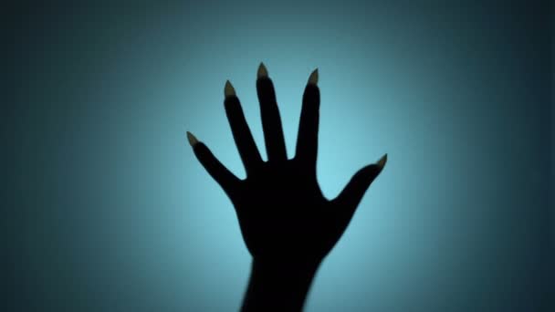 Creepy hand with long sharp nails beating on glass, blood-chilling horror scene — Stock Video