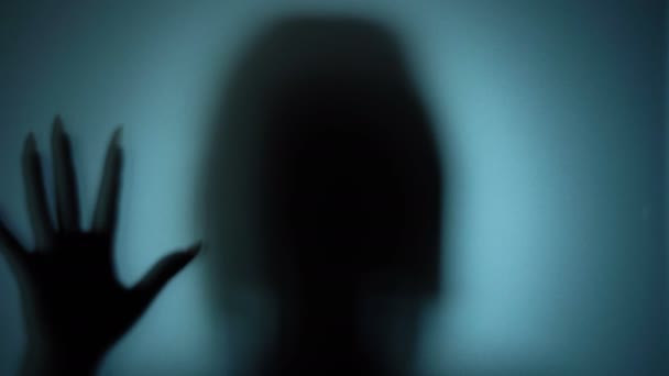Mulher fantasmagórica em um lugar assombrado, sombra silenciosa atrás de vidro, cena de horror — Vídeo de Stock