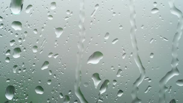 Macro raindrops on window glass, raining outside, clear water, background — Stock Video