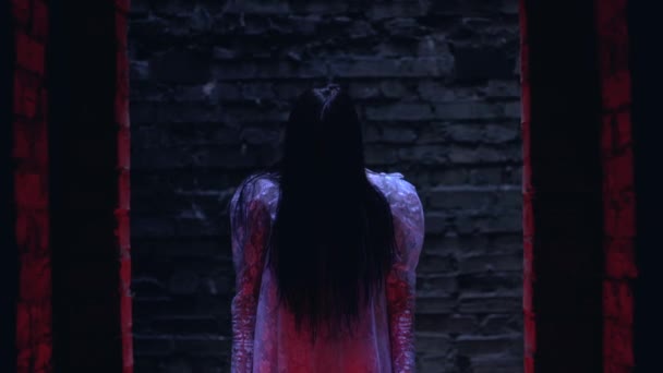 可怕的巫婆带着红色气球站在令人毛骨悚然的废弃房子里，恐怖极了 — 图库视频影像