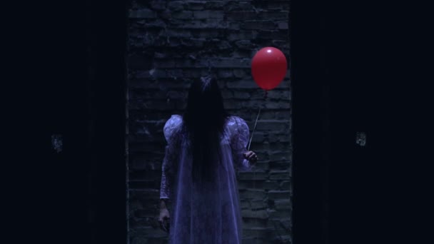 Fruktansvärd zombie brud håller röd ballong, väntar på offret på farlig plats — Stockvideo
