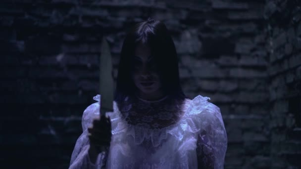 Verschrikkelijke bloederige moordenaar in witte jurk, bedreigend met scherp mes, nachtmerrie — Stockvideo