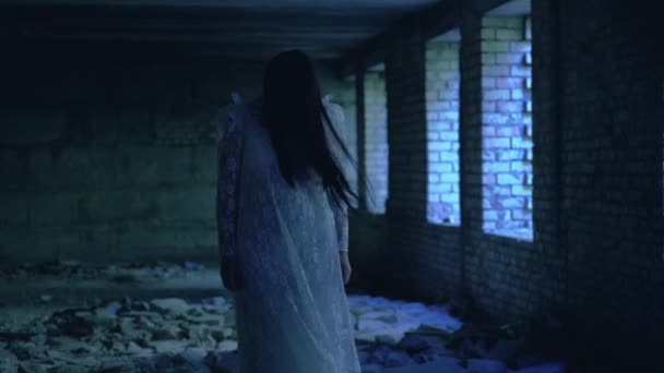 Terribile fantasma di donna dai capelli neri in abito incandescente nel buio, vento che soffia — Video Stock