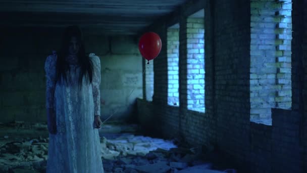 Zombie bruid in witte jurk met rode ballon, gevaarlijke sfeer, thriller — Stockvideo