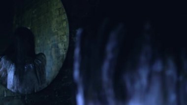 Gizemli siyah cadı aynanın önünde duruyor, yeraltı dünyasıyla bağlantı kuruyor.