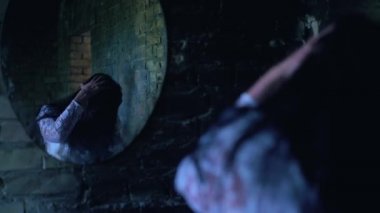 Kafasını tutup aynanın yanında kıvranan çılgın kadın, şeytan tarafından ele geçirilmiş.