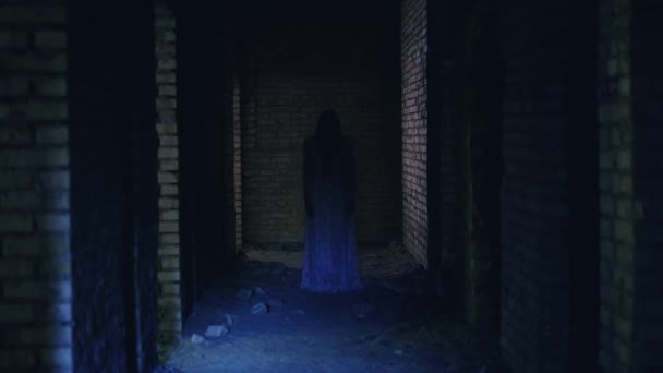 Таинственный призрак, стоящий в длинном темном коридоре, странствующий жуткий дом с привидениями — стоковое видео