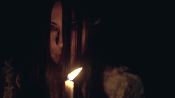 Psychotic woman burning candle and looking around in darkness, mental disorder — Stock Video