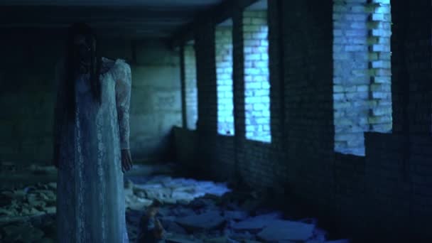 Страшное сверхъестественное существо бросает жуткую куклу в разрушенный заброшенный дом — стоковое видео