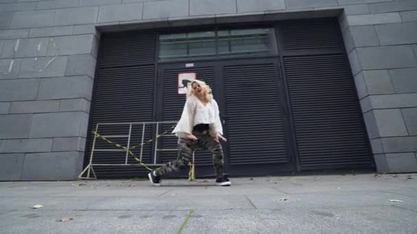 Красивая активная девушка танцует на городской улице, демонстрируя женское пухлое тело — стоковое видео