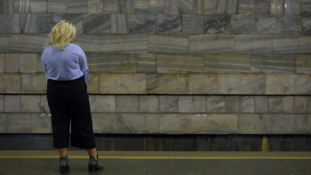Droevige overgewicht vrouw wachtend metro trein op platform alleen, lichaam onzekerheden — Stockvideo