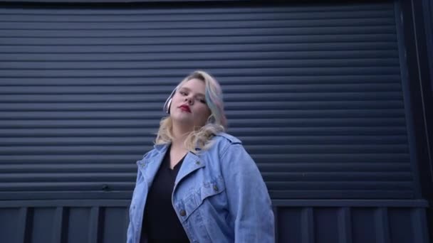 Flirtig fashionista flicka njuter av musik i hörlurar dans, urban livsstil — Stockvideo