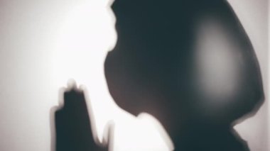 Hastanede dua eden hemşire silueti, hastalar için Tanrı 'dan merhamet diliyor, inanç.