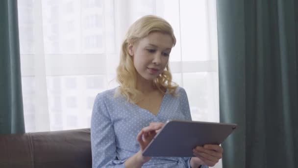 Jovem preocupada lendo más notícias on-line, segurando tablet, aplicativo de rede social — Vídeo de Stock