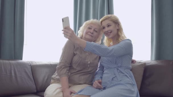 Ung kvinna och äldre mor som tar selfie via smartphone, ha kul hemma — Stockvideo