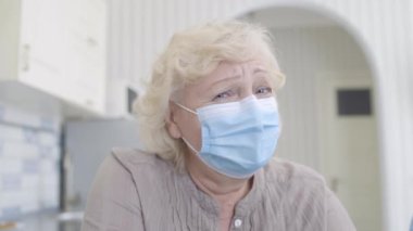 Koruyucu maske takan umutsuz kadın emekliler kameraya bakıyor, salgın hastalık gibi.