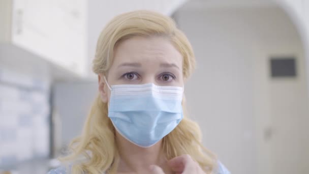 Crying young female in mask looking at camera, scared of dangerous disease — Stock Video