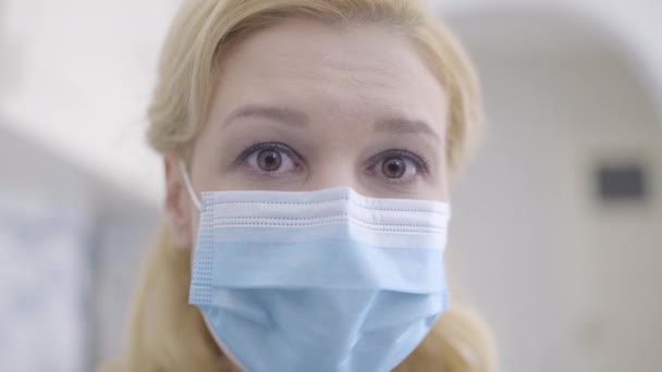 Ανήσυχη γυναίκα με μάσκα κοιτάζοντας την κάμερα, αίσθημα κατάθλιψης κατά τη διάρκεια της καραντίνας — Αρχείο Βίντεο