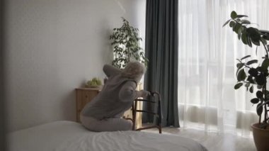 Evde yapayalnız ve çaresiz bir şekilde tek başına yürüyen yaşlı bir kadın.