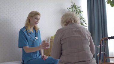 Nazik doktor yaşlı hastaya vitamin hapı veriyor, tıbbi bakım, bakım evi...