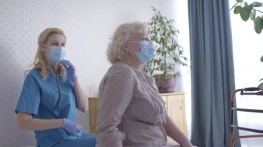 Aile doktorunun evde yaşlı kadını muayene etmesi, iyi sonuçlar, iyileşme umudu.