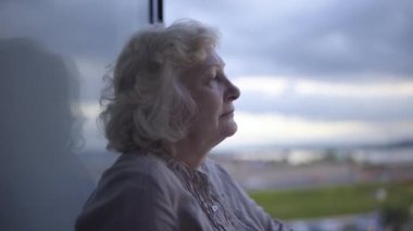Terk edilmiş yaşlı kadın balkonda duruyor depresyon ve yalnızlık çekiyor.