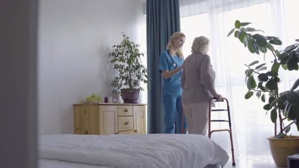 Nuttige vrouwelijke verpleegster ondersteunen depressieve oude vrouw in het ziekenhuis, gezondheidszorg — Stockvideo