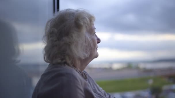 Femme âgée solitaire regardant le paysage urbain, souffrant de solitude, de problèmes de vieillissement — Video