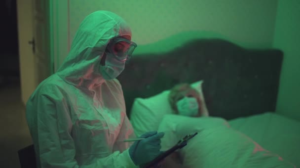 Doctor in protective gear sick infectious patient lying in bed, disease outbreak — Stock Video