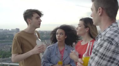 Bir grup öğrenci haberleri tartışıyor, açık havada şişelerden içiyor, iletişim kuruyorlar.