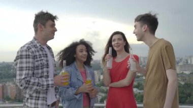 Mutlu gençler eğleniyor, açık hava partisinde şişe tokuşturuyor, birliktelik...
