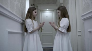 Zombi ikiz kardeşler boş koridorda el çırpma oyunu oynuyorlar. Ürkütücü korku ortamı.