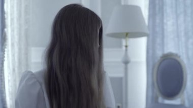 Gizemli güç kullanan yaramaz doğaüstü küçük kız, odada ışık yanıp sönüyor.