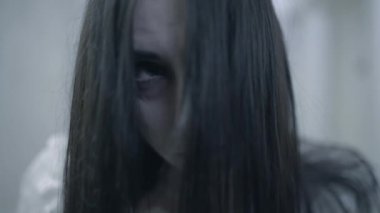 Korkunç çılgın gözleri olan ele geçirilmiş bir kadın kameraya, psikopata, korkuya bakıyor.