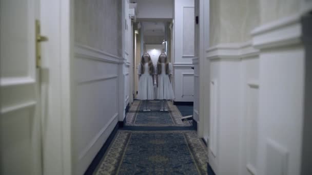 Девочки-близнецы-зомби пялятся на жертву, стоящую в коридоре, кровавый триллер — стоковое видео