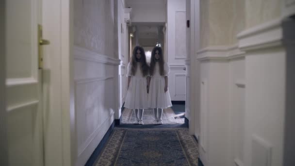 Étranges jumeaux pointant du doigt la victime, créatures surnaturelles dans le hall vide — Video