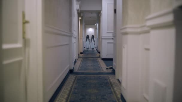 Ikerlányok rémálomszerű szellemei állnak az üres folyosón, kísértetjárta szállodai horror — Stock videók