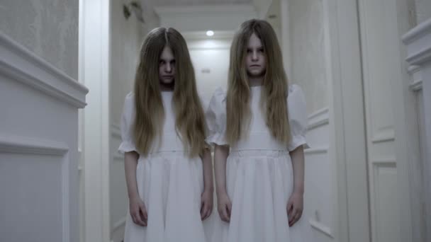 Niñas gemelas con caras pálidas mortales mirando a la leva, criaturas zombies de miedo — Vídeo de stock