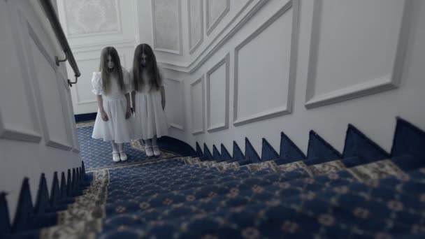 Horrifying twin girls standing at stairs, looking at cam, haunted house thriller — Stock Video