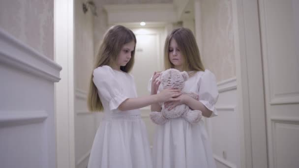Oyuncak ayıyla oynayan üzgün küçük kızlar yetimhanede terk edilmiş, mutsuz bir çocukluk. — Stok video