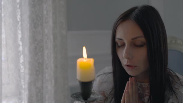 Modląca się kobieta patrząca na zdmuchnięcie świecy, znak duchowy, cud religijny — Wideo stockowe