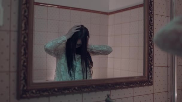 Zombie kvinde foran spejlet, dæmonisk besættelse i hjemsøgt hotel, ondt – Stock-video