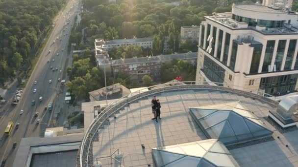 Vue aérienne de l'homme fort femme debout dos à dos sur le toit, la vie active — Video