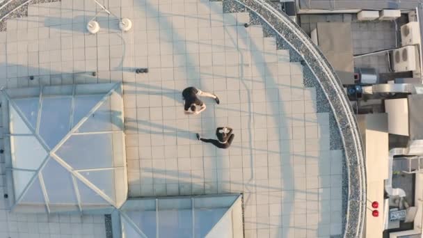 Здоровый мужчина и женщина растягивают мышцы, активные тренировки на открытом воздухе на крыше — стоковое видео