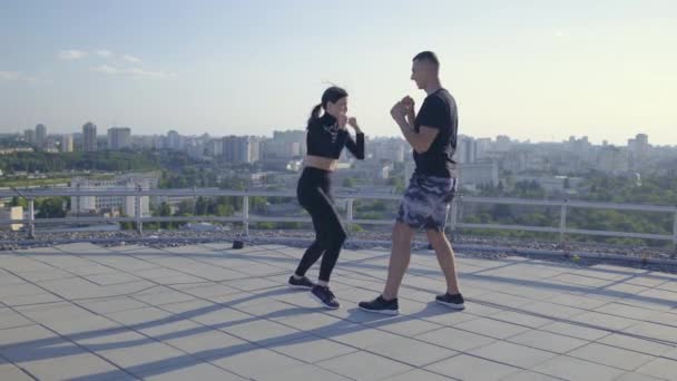 Junger Mann lehrt Freundin, wie man boxt, Paar macht Übungen zusammen, Einheit — Stockvideo